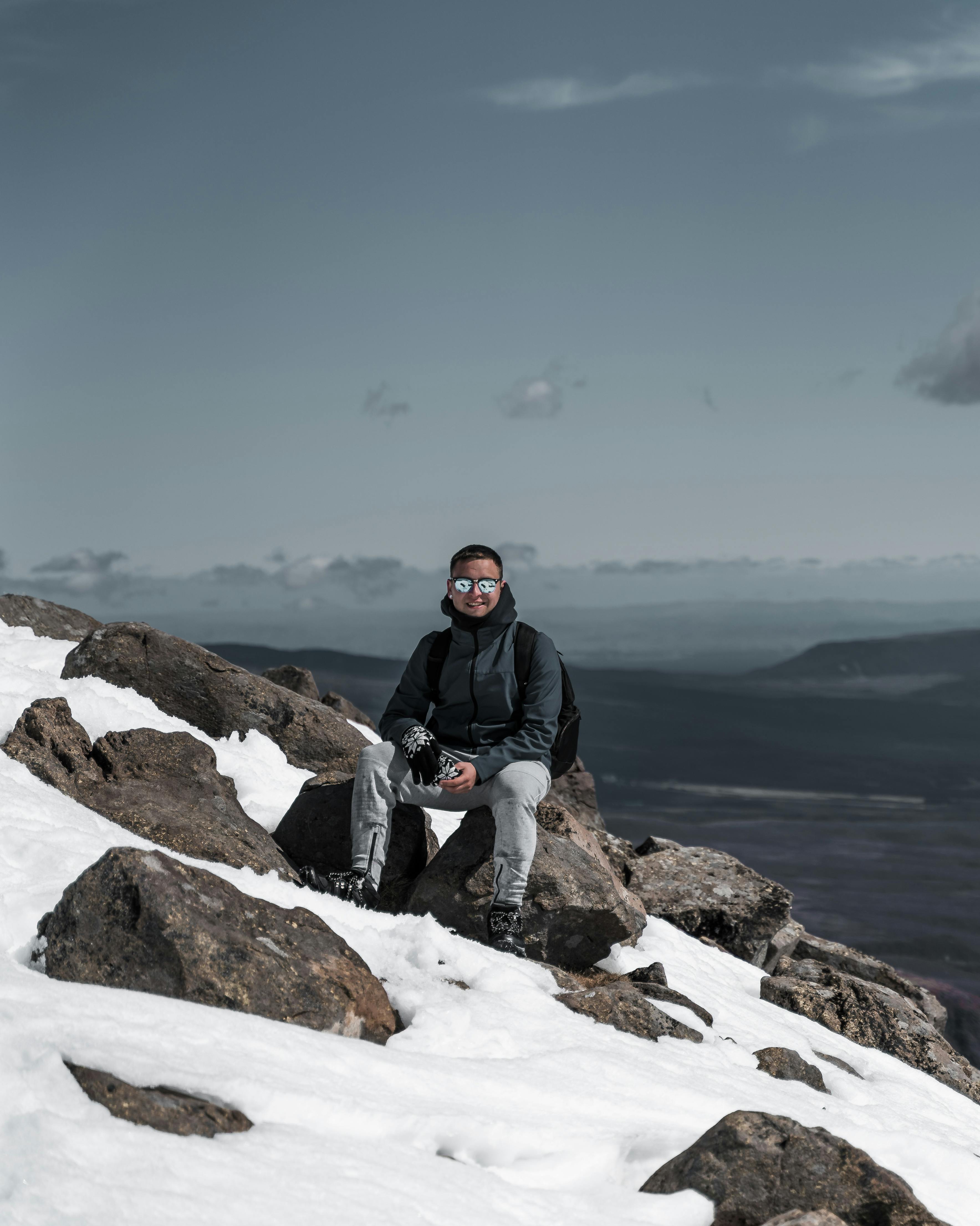 Climber on a rock face with sunglasses in bright alpine conditions