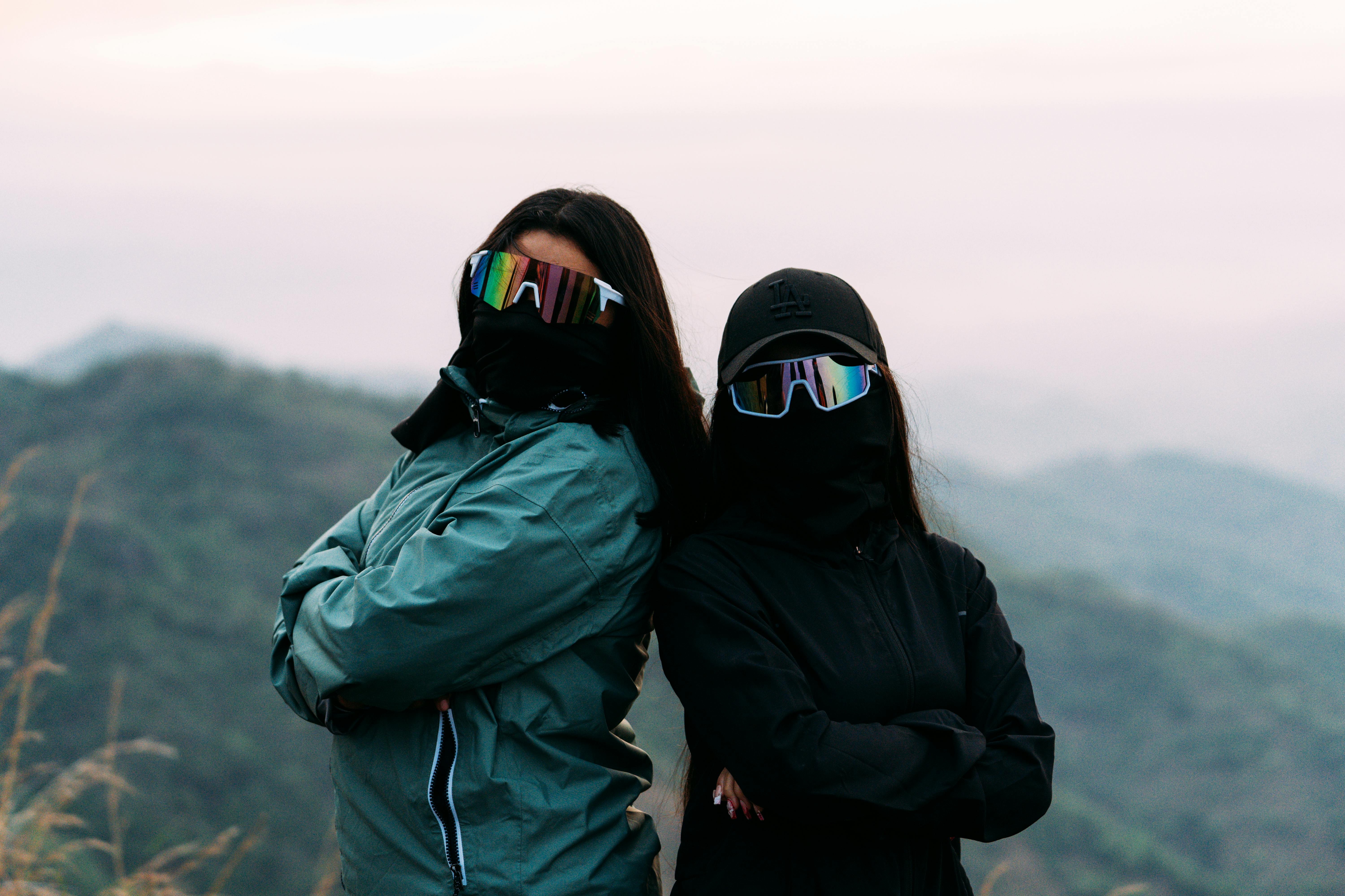 Person cleaning sunglasses outdoors on a trail