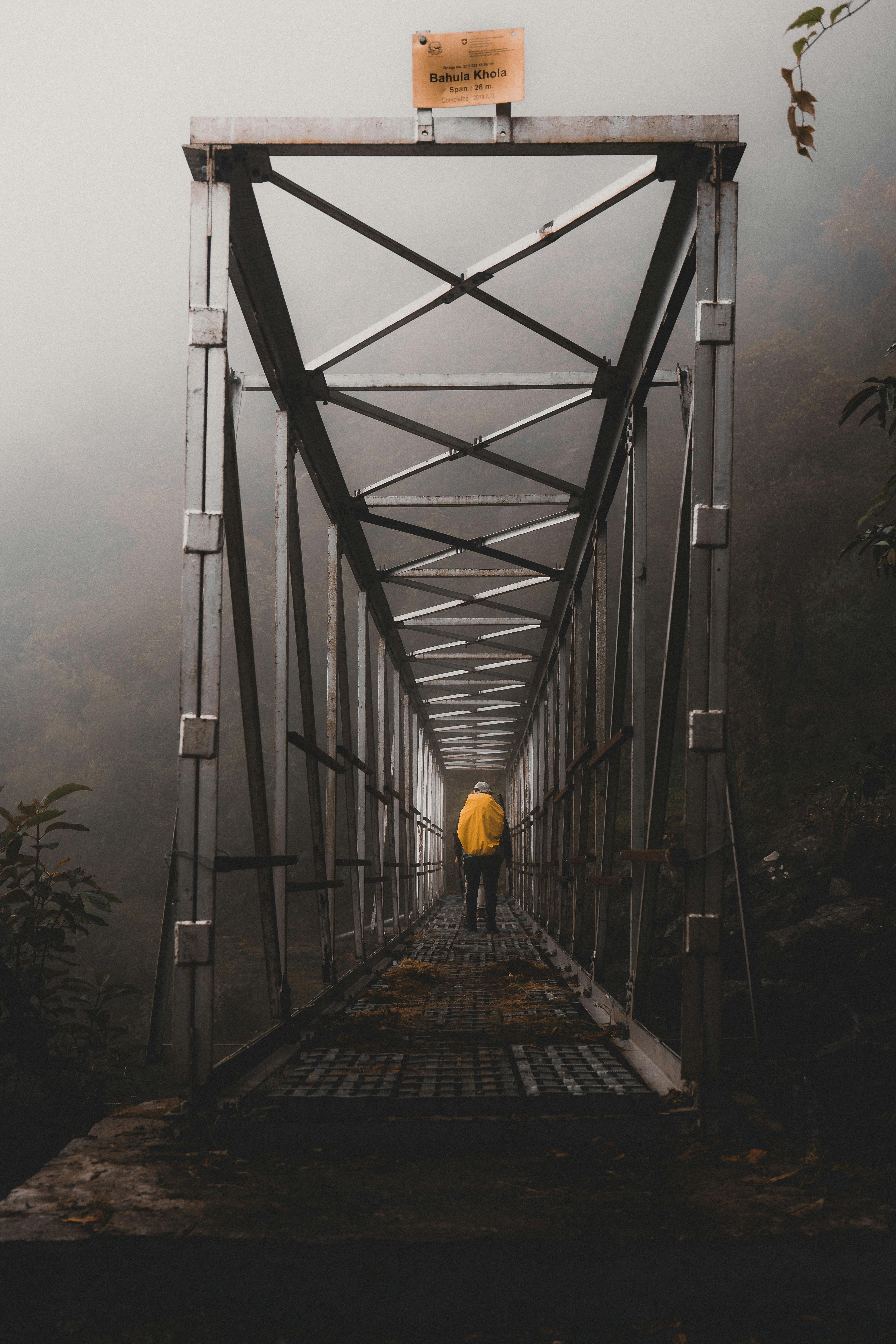 Hiker on a misty mountain trail with overcast sky